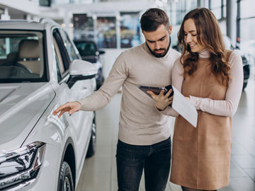 Frau zeigt Mann ein Autoverkauf Angebot auf dem Tablet bei Autoankauf Dormagen